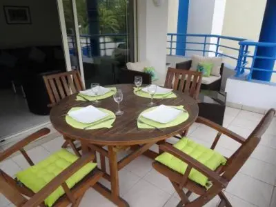 a wooden table with two chairs and a table with wine glasses at Modern one bedroomed apartment just off the Cannes Seafront with a terrace and pool access 1753 in Cannes