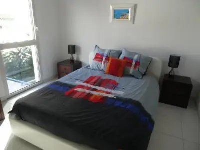 a bedroom with a large bed with colorful pillows at Modern one bedroomed apartment just off the Cannes Seafront with a terrace and pool access 1753 in Cannes