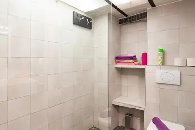 a white tiled bathroom with a shower and a toilet at Atelier & Galerie in Cannes