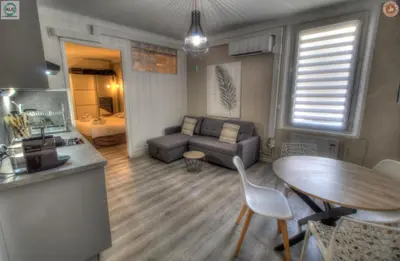 a kitchen and a living room with a table and a couch at ALC - FF39 - 9 min Palais and Beaches in Cannes