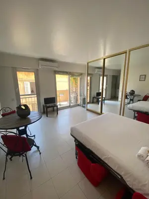 a bedroom with a bed and a table and chairs at Studio à deux pas du Palais des Festivals in Cannes
