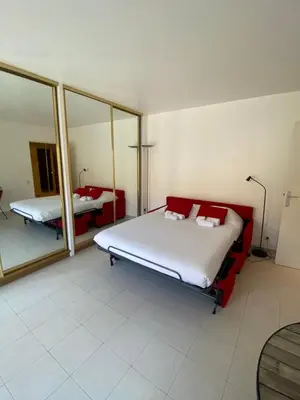 a bedroom with two beds and a mirror at Studio à deux pas du Palais des Festivals in Cannes