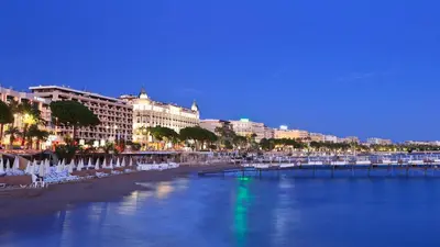 a view of a beach with white chairs and buildings at Studio à deux pas du Palais des Festivals in Cannes