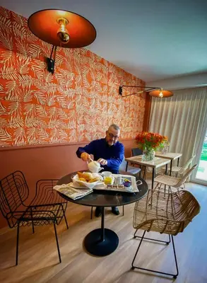 a man sitting at a table with a plate of food at Hotel Molière in Cannes