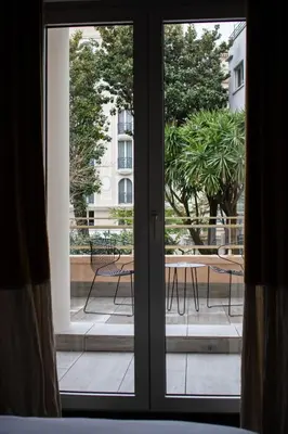 a sliding glass door with a view of a patio at Hotel Molière in Cannes
