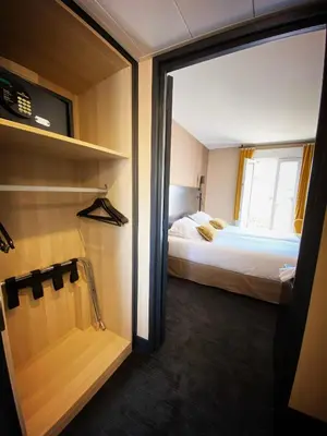 a small room with a bed and a closet at Hotel Molière in Cannes