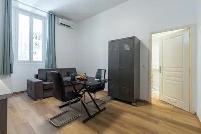 a living room with a table and a couch at Florella Marceau Apartment in Cannes