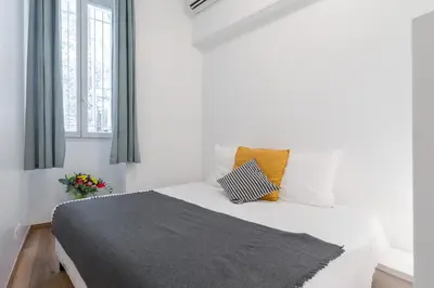 a bedroom with a white bed with two pillows at Florella Marceau Apartment in Cannes