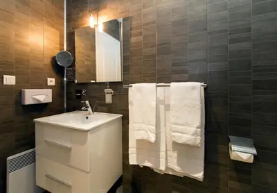 a bathroom with a sink and a mirror and towels at Florella Marceau Apartment in Cannes