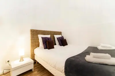 a bedroom with two beds and a table with a lamp at Florella Marceau Apartment in Cannes