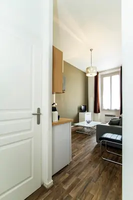 a room with a white door and a living room at Florella Marceau Apartment in Cannes
