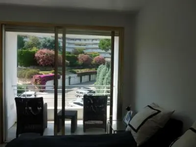 a living room with a couch and a glass door at Two Bed apartment in a gated residence with gardens in Cannes with sea views 865 in Cannes
