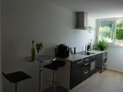 a kitchen with a sink and a counter with stools at Two Bed apartment in a gated residence with gardens in Cannes with sea views 865 in Cannes