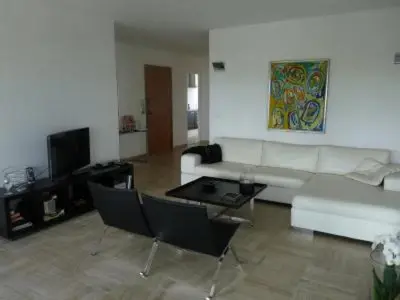 a living room with a white couch and a table at Two Bed apartment in a gated residence with gardens in Cannes with sea views 865 in Cannes