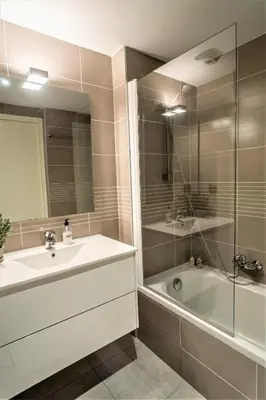a bathroom with a sink and a tub and a mirror at Modern 1-Bed Apt near Croisette Palais - 1903 in Cannes