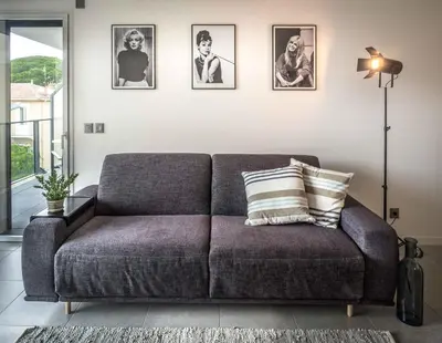 a couch in a living room with pictures on the wall at Modern 1-Bed Apt near Croisette Palais - 1903 in Cannes