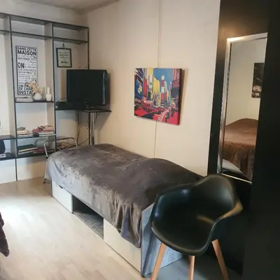 a bedroom with a bed and a chair and a television at Notre Dame in Cannes