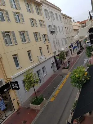 an empty city street with buildings and trees at Notre Dame in Cannes