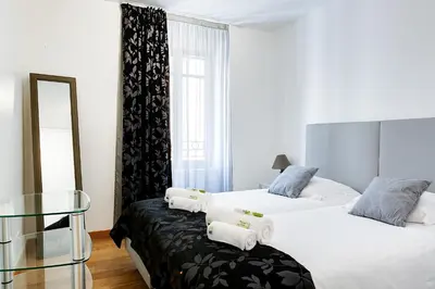 a bedroom with two beds and a glass table at IMMOGROOM - 8 min from the Palais - AC - Quai St Pierre in Cannes