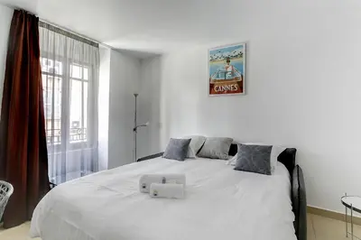 a bedroom with a large white bed with two boxes on it at IMMOGROOM - 8 min from the Palais - AC - Quai St Pierre in Cannes
