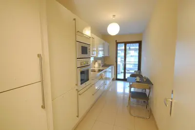 a large kitchen with a table and a microwave at Residence Gray d'Albion 2P ALI1165 in Cannes