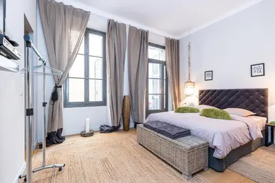 a bedroom with a large bed and windows at Travel lodge in Cannes