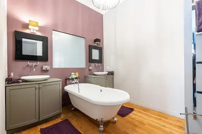 a bathroom with a tub and two sinks and a mirror at Travel lodge in Cannes