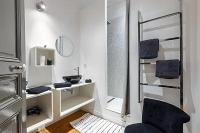 a small bathroom with a mirror and a chair at Travel lodge in Cannes
