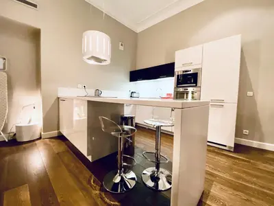 a kitchen with white cabinets and a counter with stools at Le Cid 3P CIR3374 in Cannes
