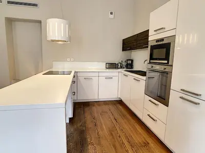 a white kitchen with white appliances and wooden floors at Le Cid 3P CIR3374 in Cannes