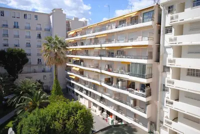 an apartment building with balconies and palm trees at Palais Rouaze 2P SOM2151 in Cannes