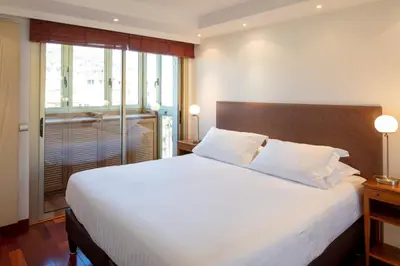 a bedroom with a large white bed and a window at Rabelais in Cannes