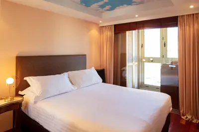 a bedroom with a large white bed and a window at Rabelais in Cannes