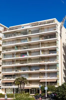 a large apartment building with palm trees in front of it at Rabelais in Cannes