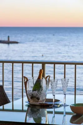 a bottle of champagne sitting on a table with glasses at Rabelais in Cannes
