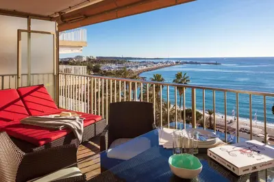 a balcony with a table and chairs and the ocean at Rabelais in Cannes