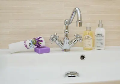a sink with a faucet and two bottles of soap at Appartement CANNES IMPERIAL Pointe Croisette in Cannes