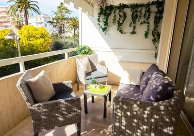 a balcony with two chairs and a table on a balcony at Appartement CANNES IMPERIAL Pointe Croisette in Cannes