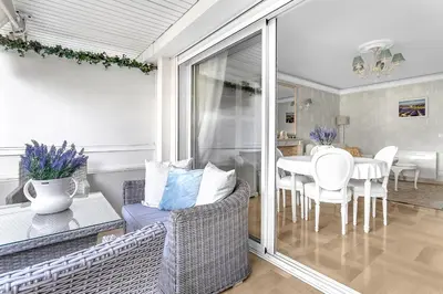 a living room with a couch and a table with chairs at Appartement CANNES IMPERIAL Pointe Croisette in Cannes