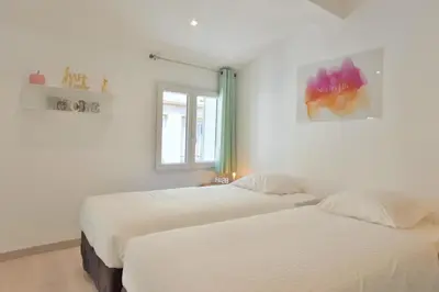 two beds in a room with white walls and a window at Studio Elly in Cannes