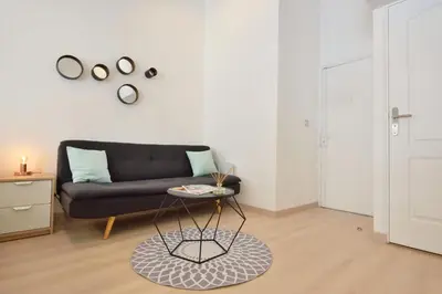 a living room with a black couch and a table at Studio Elly in Cannes