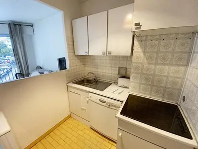 a small kitchen with white cabinets and a sink at Palm d'Or KAR146 2P in Cannes