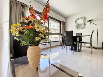 a vase filled with flowers on a glass table in a room at Gray d'Albion studio BON500 in Cannes