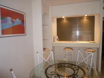 a dining room with a glass table and two stools at Residence Gray d'Albion Studio DEL186 in Cannes
