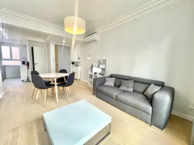 a living room with a couch and a table at Pasteur by Welcome to Cannes in Cannes