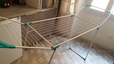 a metal rack in a kitchen next to a refrigerator at Forville in Cannes
