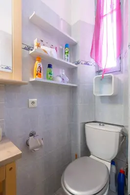a bathroom with a white toilet and a pink curtain at Forville in Cannes