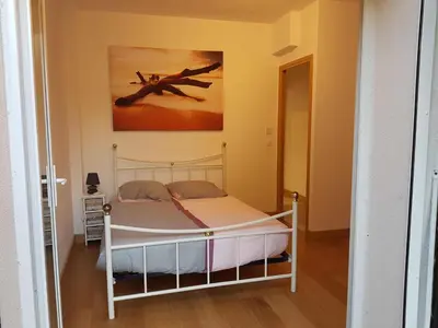 a bedroom with a bed with a painting on the wall at les orangers in Cannes