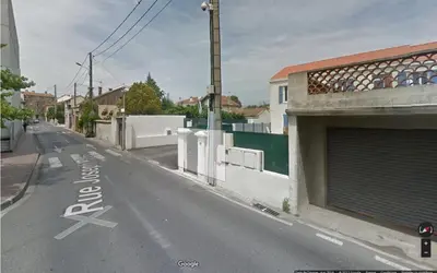 an empty street with a building and a gate at les orangers in Cannes