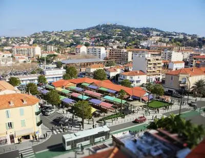 a city with buildings and a street with a bus at les orangers in Cannes
